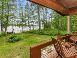 a porch with chairs and a table and a view of the water at Holiday Home Kuusiranta by Interhome in Harjula