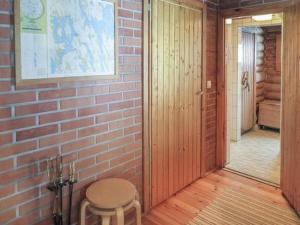 a room with a brick wall and a stool and a corridor at Holiday Home Hepolehto by Interhome in Säkinmäki +14 photos
