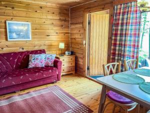 a living room with a purple couch and a table at Holiday Home Kuusiranta by Interhome in Harjula