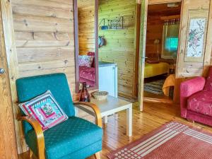 a living room with a chair and a table at Holiday Home Kuusiranta by Interhome in Harjula +8 photos