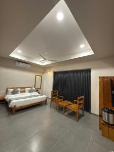 a bedroom with a bed and a table and chairs at Daksh The Nirvana Retreat in Vitoj