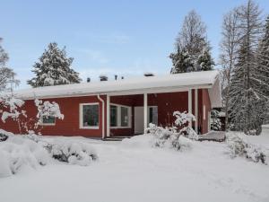 a red house covered in snow with trees at Holiday Home Suvela by Interhome in Kukkola