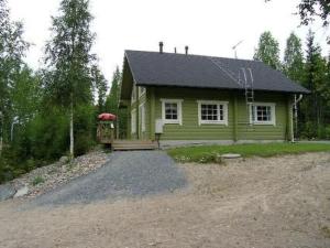 a small green house with a porch and a driveway at Holiday Home Villa helmi by Interhome in Holiseva