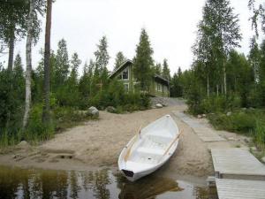 a boat sitting in the water next to a house at Holiday Home Villa helmi by Interhome in Holiseva