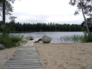 a boat on a dock next to a lake at Holiday Home Villa helmi by Interhome in Holiseva