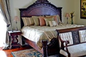 Un dormitorio con una gran cama de madera con almohadas en Dansereau House, en Thibodaux