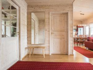a living room with a door and a red rug at Holiday Home Kaislaranta by Interhome in Lahdenkylä