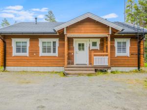 a wooden house with a white door at Holiday Home Kaislaranta by Interhome in Lahdenkylä