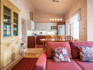 a living room with a couch and a kitchen at Holiday Home Kaislaranta by Interhome in Lahdenkylä