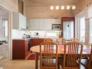 a kitchen with a wooden table and wooden chairs at Holiday Home Kaislaranta by Interhome in Lahdenkylä +17 photos