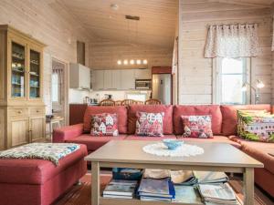 a living room with a red couch and a table at Holiday Home Kaislaranta by Interhome in Lahdenkylä