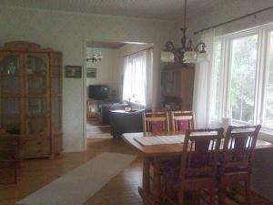 a living room with a table and a dining room at Holiday Home Simola by Interhome in Nimimäki