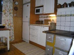 a kitchen with white appliances and a counter top at Holiday Home Simola by Interhome in Nimimäki