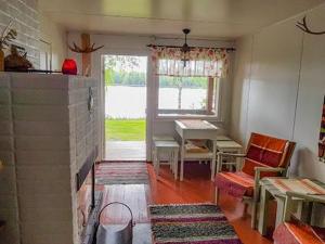 a living room with a table and a fireplace at Holiday Home Simola by Interhome in Nimimäki +15 photos
