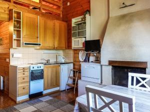 a kitchen with white appliances and wooden cabinets at Holiday Home Lupposyöte b1 by Interhome in Syöte