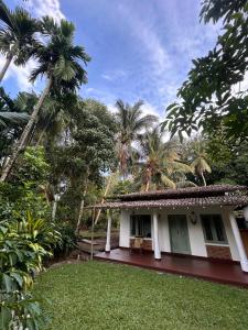 a house with palm trees in front of it at LEONS Stay in Galle