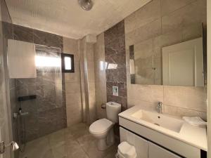 a bathroom with a toilet and a sink and a mirror at Maia Suites in Çeşme +23 photos
