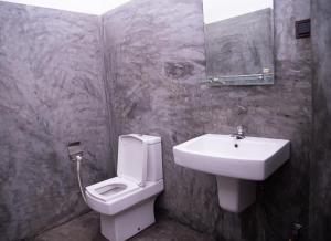 a bathroom with a white toilet and a sink at LEONS Stay in Galle +28 photos