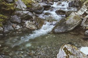 a stream of water with rocks in a river at Waterfall Retreat in Kolo