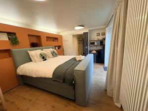 a bedroom with a bed with an orange wall at Duna - Japandi B&B met topontbijt & wellness in Koksijde