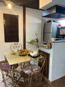a kitchen with a table with a bowl of fruit on it at Lovely flat in nice garden in Rabat +22 photos