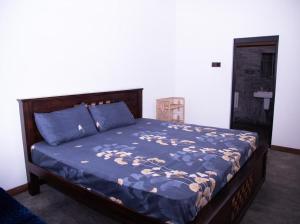 a bedroom with a bed with a blue comforter at LEONS Stay in Galle