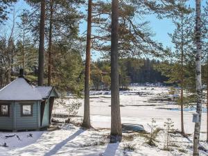 a small house in the snow next to some trees at Holiday Home Marjaranta by Interhome in Konnevesi