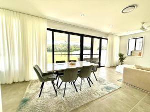 a dining room with a table and chairs and a couch at The Calypso Bay in Jacobs Well