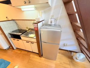 a small kitchen with a sink and a refrigerator at ハイツロフト102 in Nagasaki