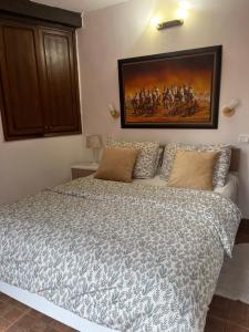 a bedroom with a bed with a painting on the wall at Lovely flat in nice garden in Rabat