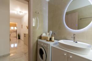 a bathroom with a sink and a washing machine at Amelia Summer Homes in Pérdika
