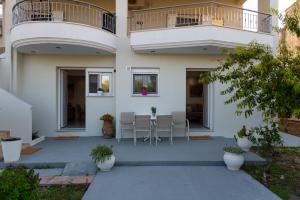 a building with a patio with chairs and a balcony at Amelia Summer Homes in Pérdika