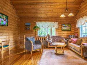 a living room with furniture in a log cabin at Holiday Home Sarvitupa by Interhome in Kangashäkki