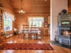 a dining room with a table and a fireplace at Holiday Home Sarvitupa by Interhome in Kangashäkki