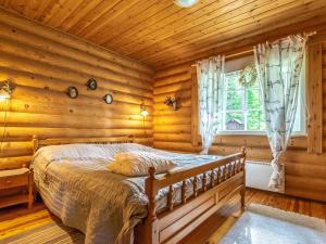 a bedroom with a bed in a log cabin at Holiday Home Sarvitupa by Interhome in Kangashäkki +16 photos