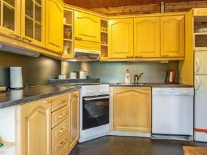 a kitchen with yellow cabinets and white appliances at Holiday Home Sarvitupa by Interhome in Kangashäkki