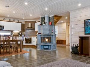 a living room with a stone fireplace in a kitchen at Holiday Home Villa sofia by Interhome in Vuokatti