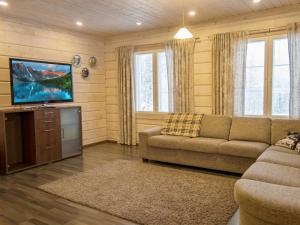 a living room with a couch and a flat screen tv at Holiday Home Villa sofia by Interhome in Vuokatti