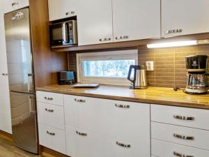a kitchen with white cabinets and a counter top at Holiday Home Villa sofia by Interhome in Vuokatti