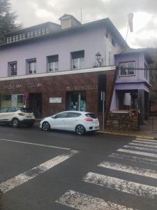 two cars parked in front of a building at Albergue Pájaro L in Castejón de Sos