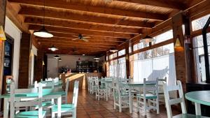 a dining room with tables and white chairs at Albergue Pájaro L in Castejón de Sos