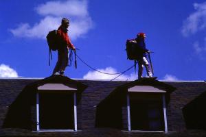 two men are on top of a roof at Albergue Pájaro L in Castejón de Sos