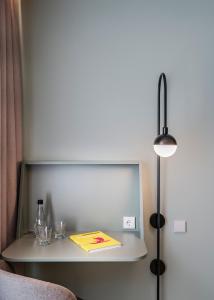 a desk with a book and a lamp on a shelf at Vincci Bonjardim in Porto