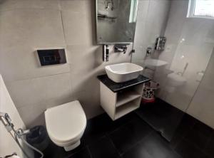 a bathroom with a white toilet and a sink at Surwel Hotel and Resort in Mussoorie