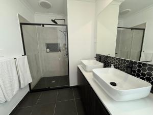 a white bathroom with a sink and a shower at The Calypso Bay in Jacobs Well +7 photos