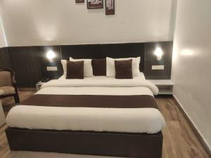 a bedroom with a large bed with a black headboard at Surwel Hotel and Resort in Mussoorie +5 photos
