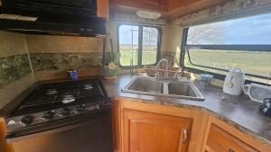 a kitchen with a sink and a stove and a window at Starry Skies RV in Victoria