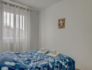 a bedroom with a bed with towels and a window at Les Peupliers Appart de Charme in Compiègne