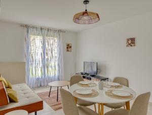 a living room with a white table and chairs at Les Peupliers Appart de Charme in Compiègne