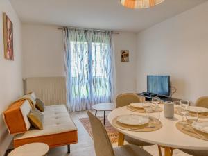 a living room with a table and chairs and a television at Les Peupliers Appart de Charme in Compiègne +24 photos